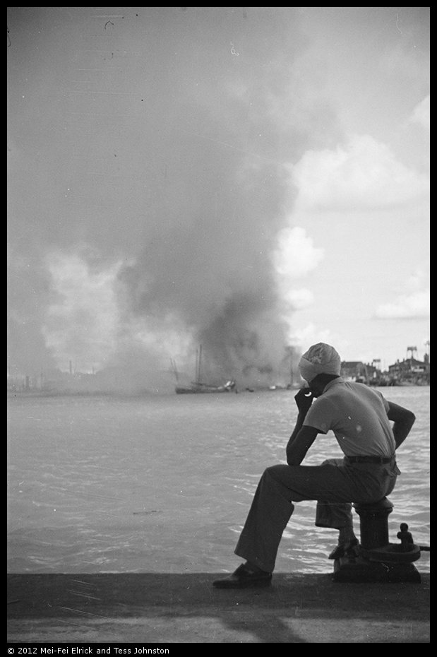 Sikh man looking over Whangpoo towards fires in Pudong, Shanghai, Rosholt Collection, Ro-n0344.