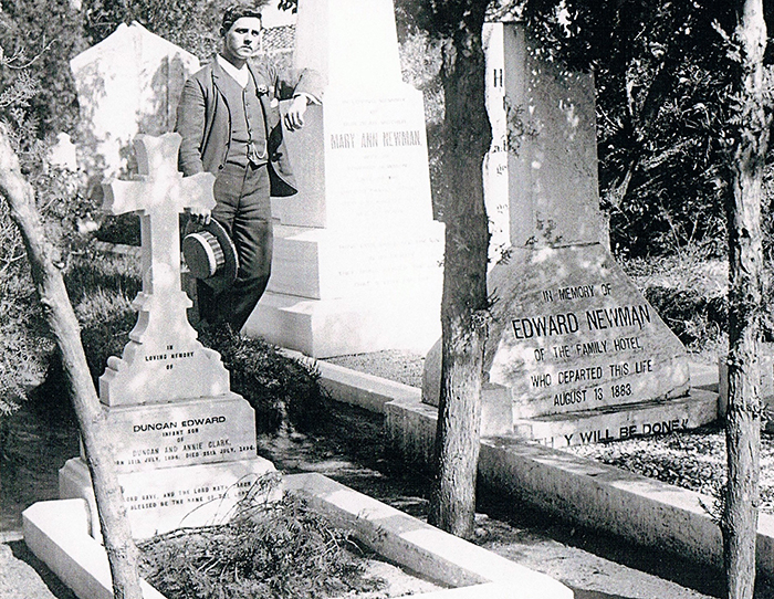 Frank Newman beside the grave stones of Mary Ann Newman and Edward Newman. Image courtesy of Duncan Clark.