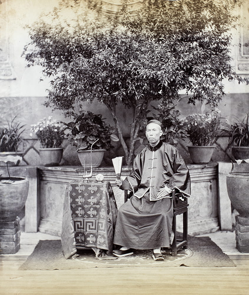 A portrait of Hopchun, c.1869, in which a tea plant is central in a symmetric composition. Photograph attributed to Lai Fong (Afong Studio), as suggested by the number written in pencil on the album page (30). See the Lai Fong (Afong Studio) number lists in ‘History of Photography in China, Chinese Photographers 1844-1879’ by Terry Bennett (Quaritch 2013), page 312. HPC ref: Fr01-046.