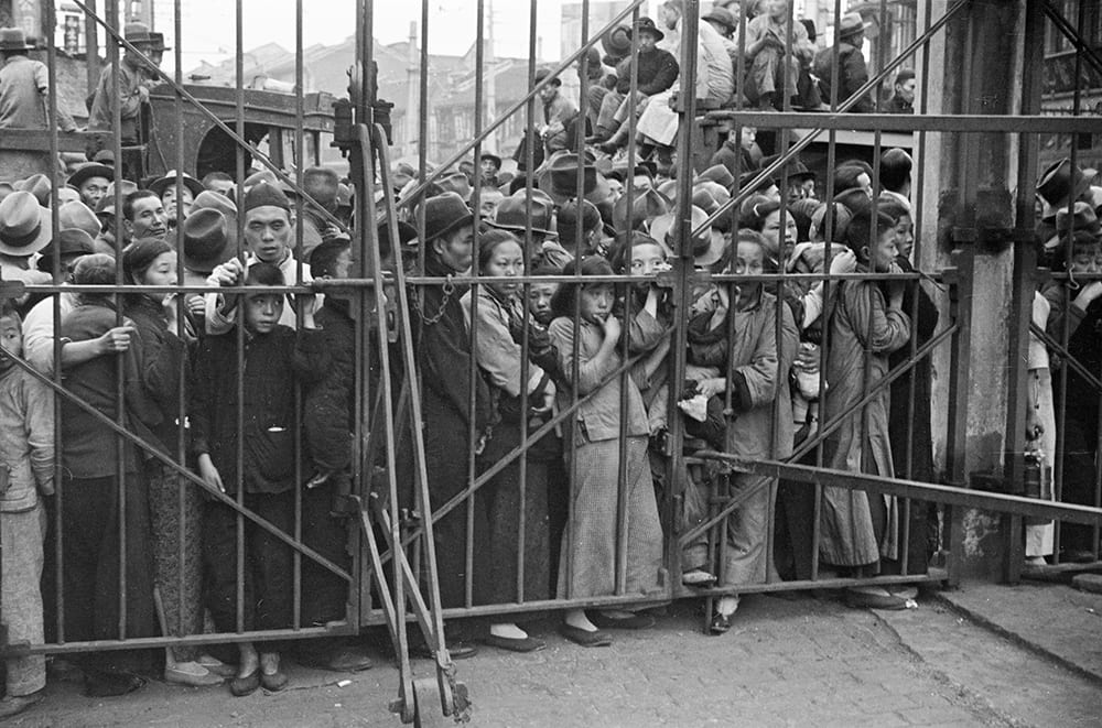 Refugees waiting by a steel gate, Shanghai. Photograph by Malcolm Rosholt. HPC ref: Ro-n0374.