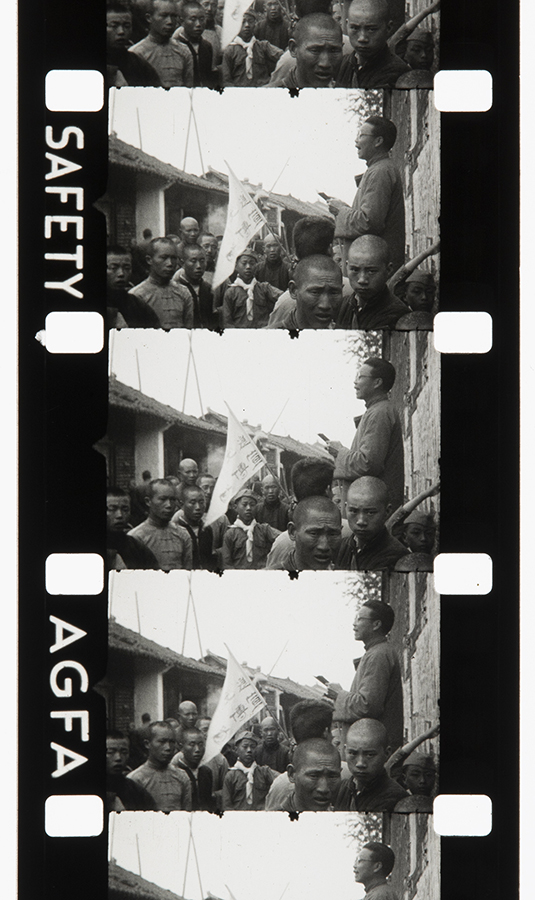 The first few frames of a roll of 16mm cine film, in the Robert Peck Collection (DM2838/4/1). This part of the footage seems to show a Christian proselytising in a street in China, c.1937. The two reels of cine film in this collection have not yet been viewed or digitised.